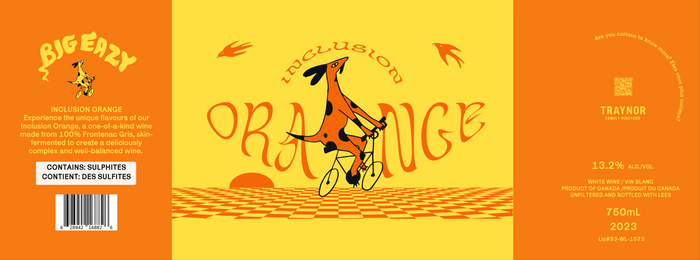 "Wine label for 'Inclusion Orange' by Traynor Family Vineyard. The label features a bright yellow and orange design with a whimsical orange dog riding a bicycle across a checkered surface. 'INCLUSION ORANGE' is written in playful, curved orange text. The left side provides a product description highlighting the wine as 100% Frontenac Gris, skin-fermented, and complex. The right side includes details like 13.2% alcohol, 750mL volume, vintage 2023, and mentions the wine is unfiltered and bottled with lees. Ad