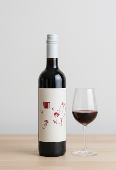 Wine bottle labeled 'Port' with a glass of wine on a wooden surface