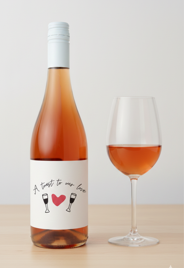 Wine bottle with a label and a glass of rose wine on a light background