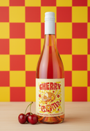 Bottle of Cherry Bomb wine with cherries on a yellow and red checkered background