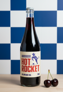 Bottle of 'Hot Rocket' VODA with cherries on a checkered blue and white background