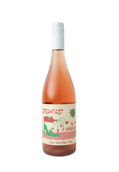 "A bottle of rosé wine labeled 'Breakfast in the Vineyard.' The label features playful illustrations of a red teapot pouring wine into small cups, with green vines extending from the teapot spout. The design includes red and green checkered patterns and bold text, with 'VQA Ontario VQA' displayed at the bottom."