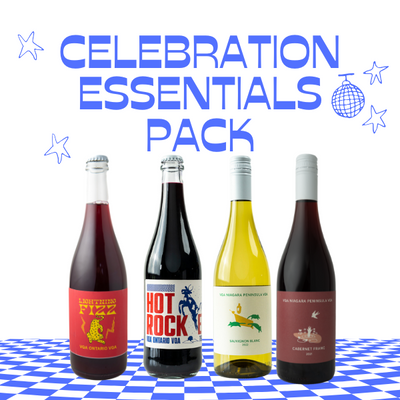 "Celebration Essentials Pack featuring four wine bottles displayed on a blue-and-white checkered surface. The pack includes vibrant labels for a sparkling red, a bold Pet-Nat, a crisp white, and a rich red. The text 'Celebration Essentials Pack' is written in bold blue, accented with star and disco ball graphics for a festive party theme."